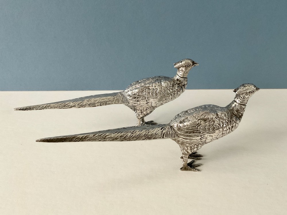 A pair of detailed solid silver pepper shakers crafted in the form of standing pheasants with long tail feathers. View III