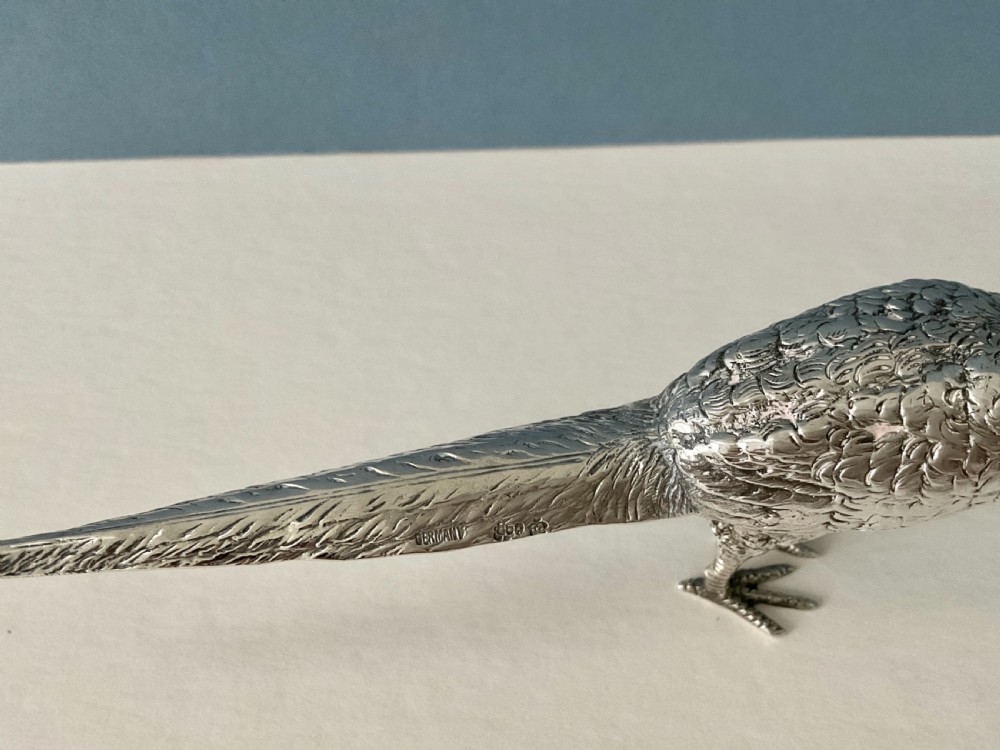 A pair of detailed solid silver pepper shakers crafted in the form of standing pheasants with long tail feathers. View V