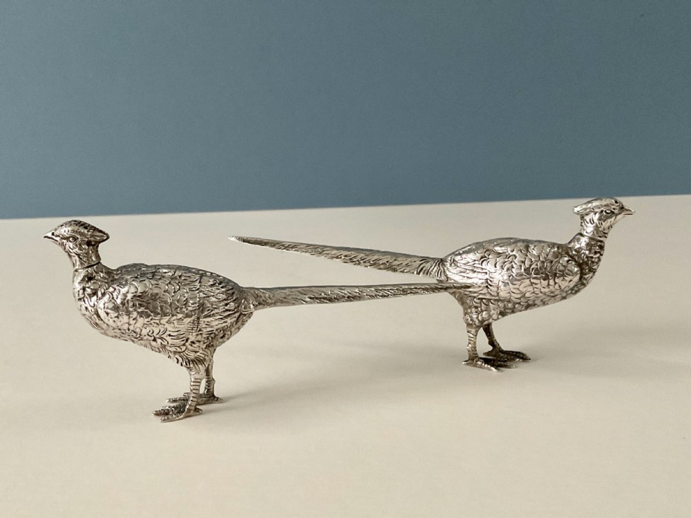 A pair of detailed solid silver pepper shakers crafted in the form of standing pheasants with long tail feathers. View VII