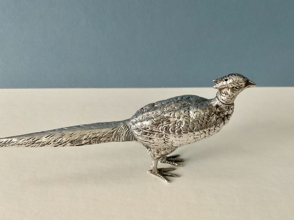 A pair of detailed solid silver pepper shakers crafted in the form of standing pheasants with long tail feathers. View IX