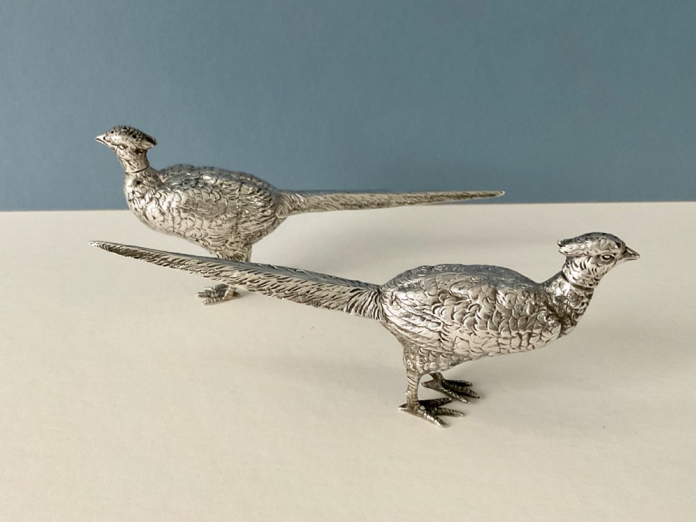 A pair of detailed solid silver pepper shakers crafted in the form of standing pheasants with long tail feathers. View X