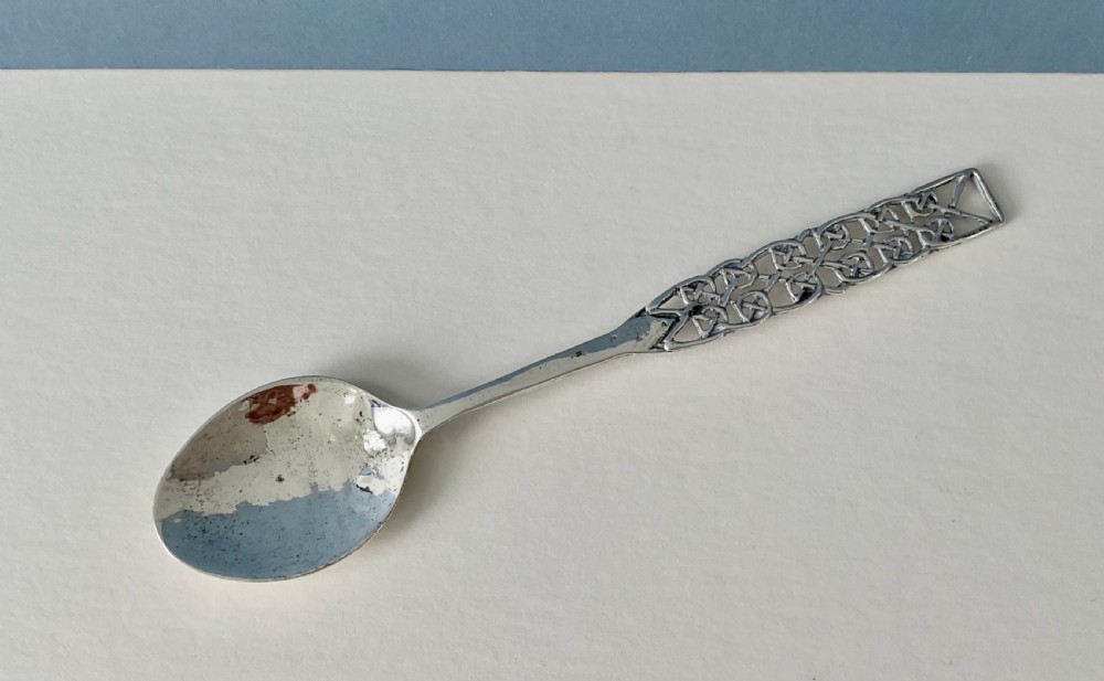 An Arts and Crafts sterling silver spoon with an oval bowl and an intricate pierced Celtic knotwork handle. View VI
