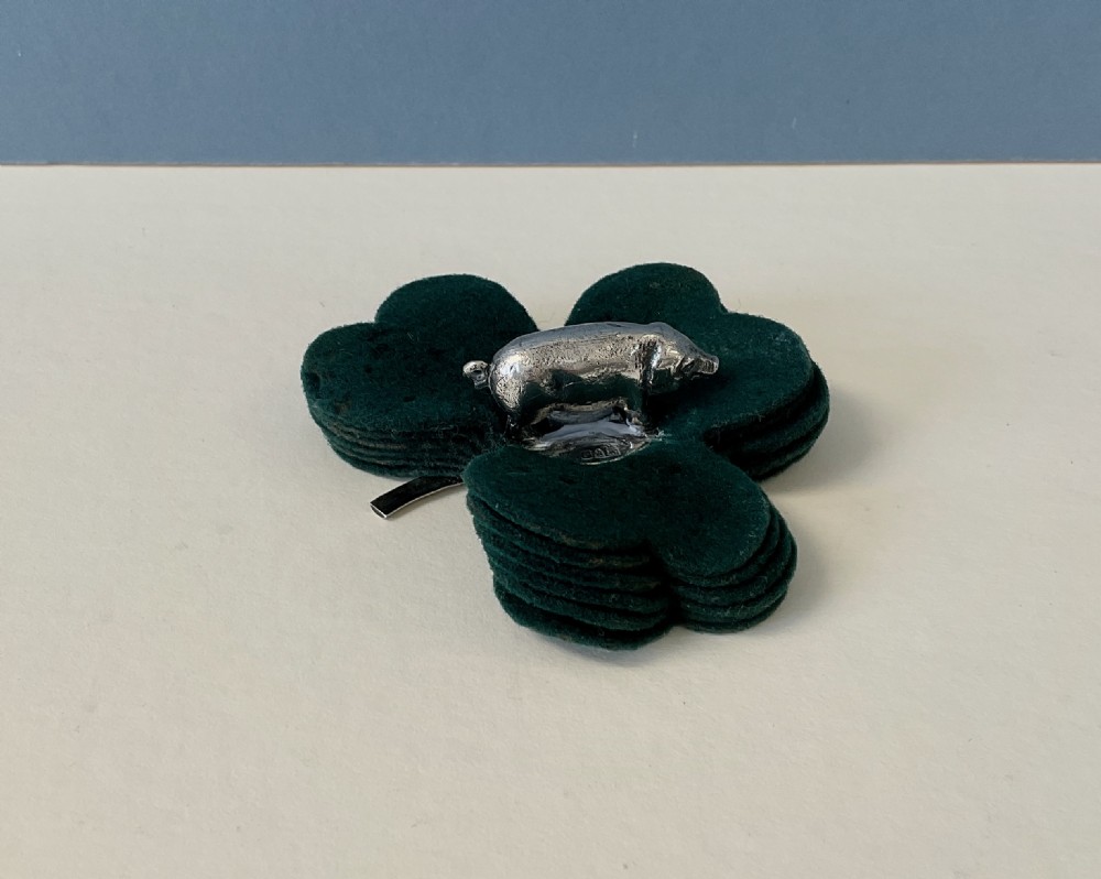 An antique silver pig finial mounted on stacked dark green clover-shaped felt pads. View VI