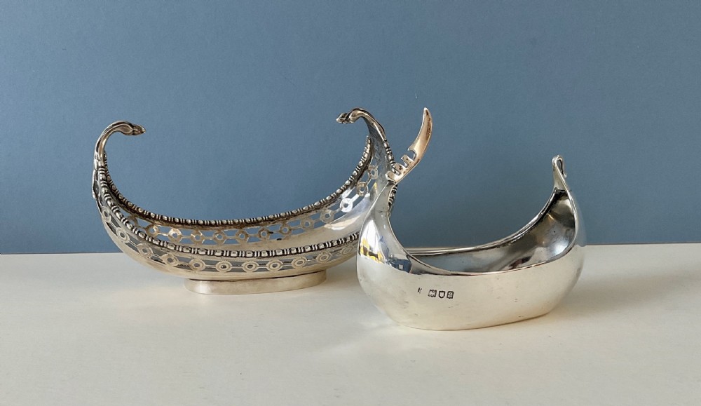 A polished silver decorative dish crafted in the shape of a Viking longship with a curved prow and stern. View VIII
