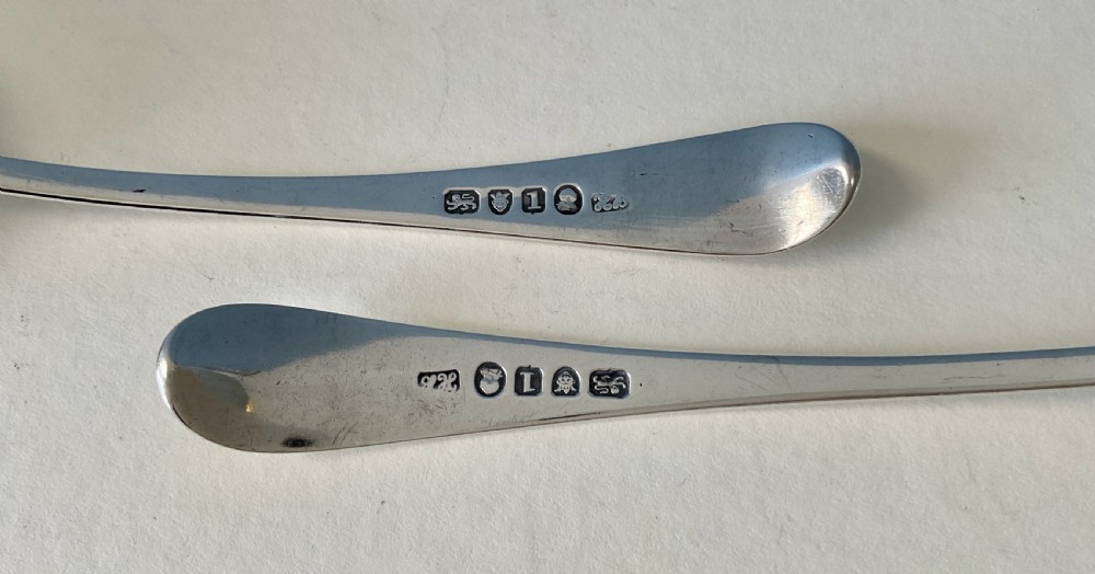 A pair of Georgian sterling silver ladles featuring curved handles with engraved crests and polished round bowls. View IV