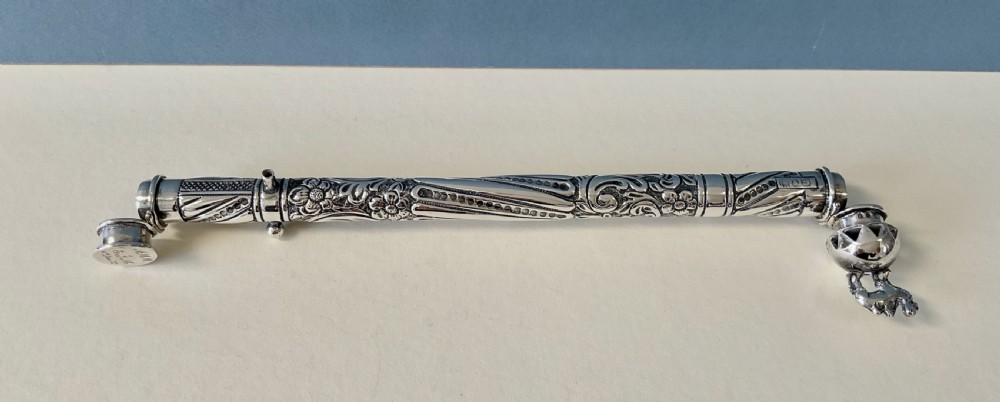 An antique cylindrical silver sealing wax holder decorated with intricate chased scrollwork, floral motifs, and a sculpted animal finial. View VI