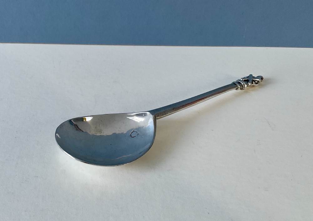 A 17th-century silver apostle spoon featuring a fig-shaped bowl, a long straight stem, and a carved saint finial. View II