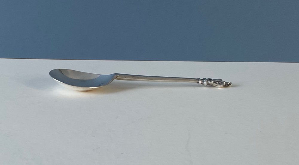 A 17th-century silver apostle spoon featuring a fig-shaped bowl, a long straight stem, and a carved saint finial. View VII