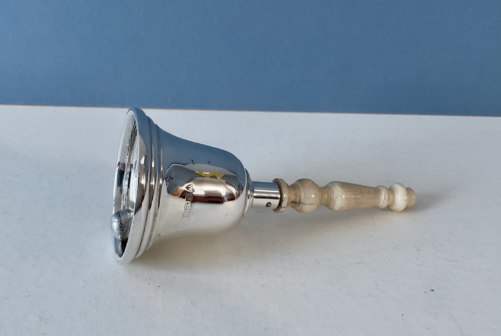 A polished silver table bell featuring a turned bone handle and hallmarks stamped on the dome. View IV