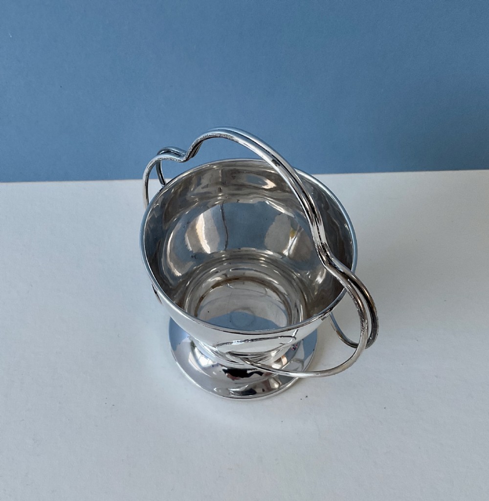 An antique silver Art Nouveau basket featuring a rounded bowl set on a pedestal base with a looping overhead handle. View III