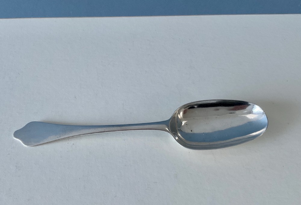 An antique silver spoon featuring an oval bowl and a flat stem with a shaped terminal. View II