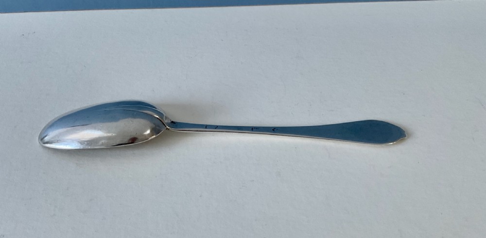 An antique silver spoon featuring an oval bowl and a slender stem terminating in a flared handle. View VI