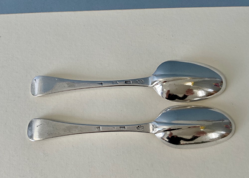 A pair of George I sterling silver spoons featuring elongated oval bowls and smooth Hanoverian stems with upturned terminals. View III