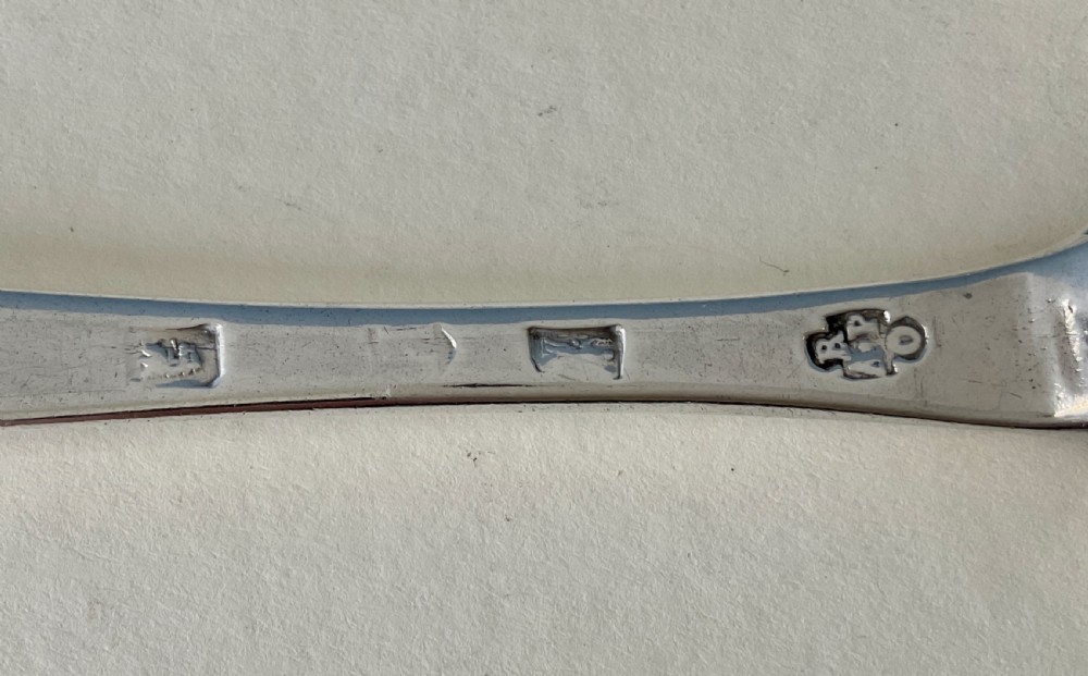 A pair of George I sterling silver spoons featuring elongated oval bowls and smooth Hanoverian stems with upturned terminals. View IV