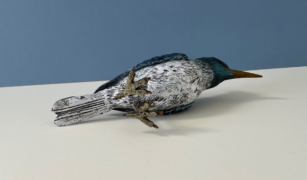 An antique cold-painted bronze figure of a crested kingfisher bird with blue, white, and bronze details standing on two legs. View V