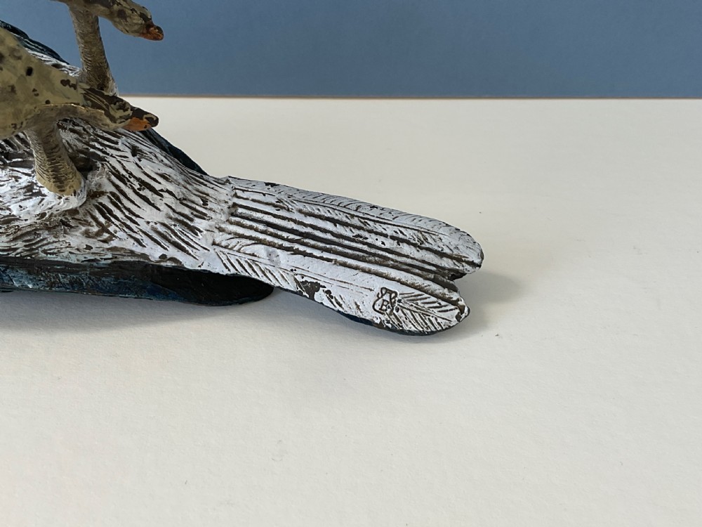 An antique cold-painted bronze figure of a crested kingfisher bird with blue, white, and bronze details standing on two legs. View VII