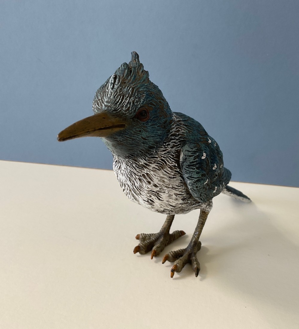 An antique cold-painted bronze figure of a crested kingfisher bird with blue, white, and bronze details standing on two legs. View VIII