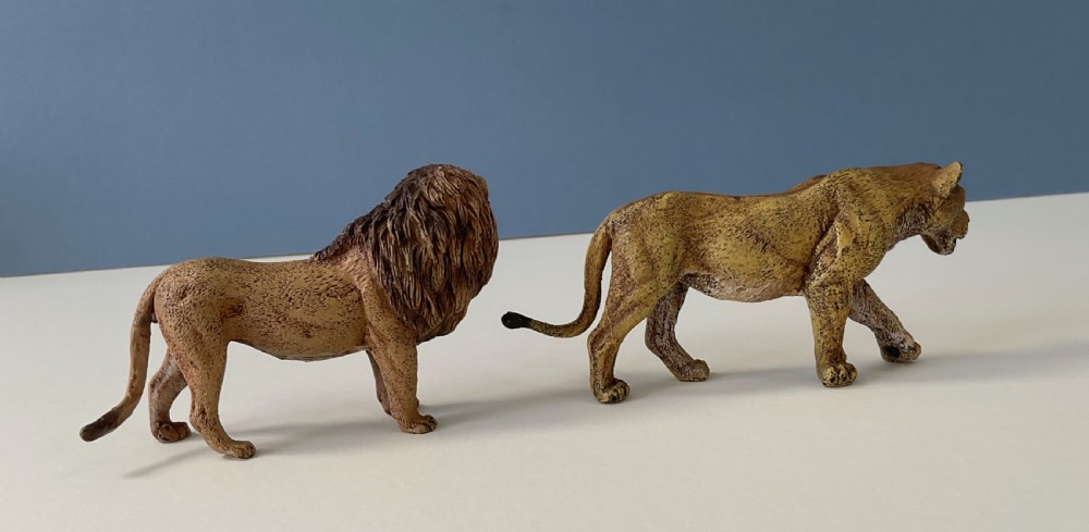 A pair of cold-painted bronze statuettes depicting a male lion and a lioness in realistic tawny brown tones. View III