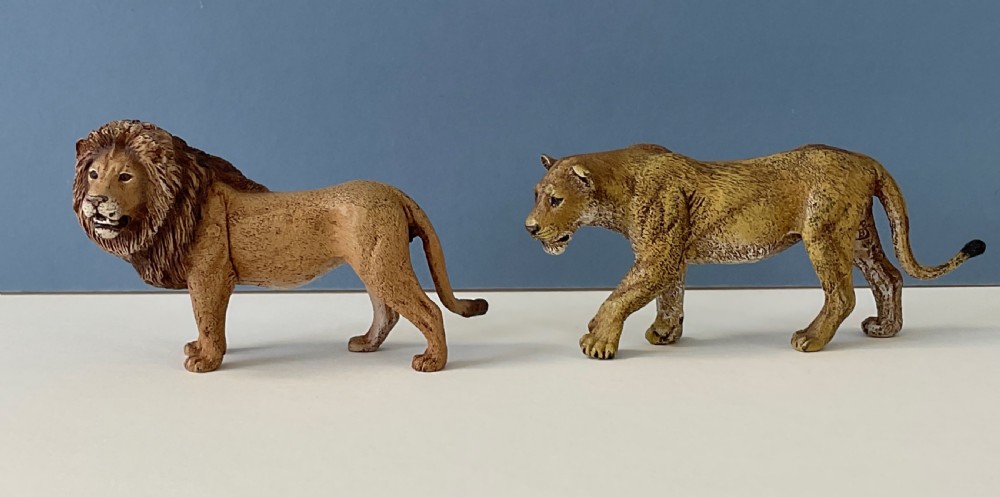 A pair of cold-painted bronze statuettes depicting a male lion and a lioness in realistic tawny brown tones. View V
