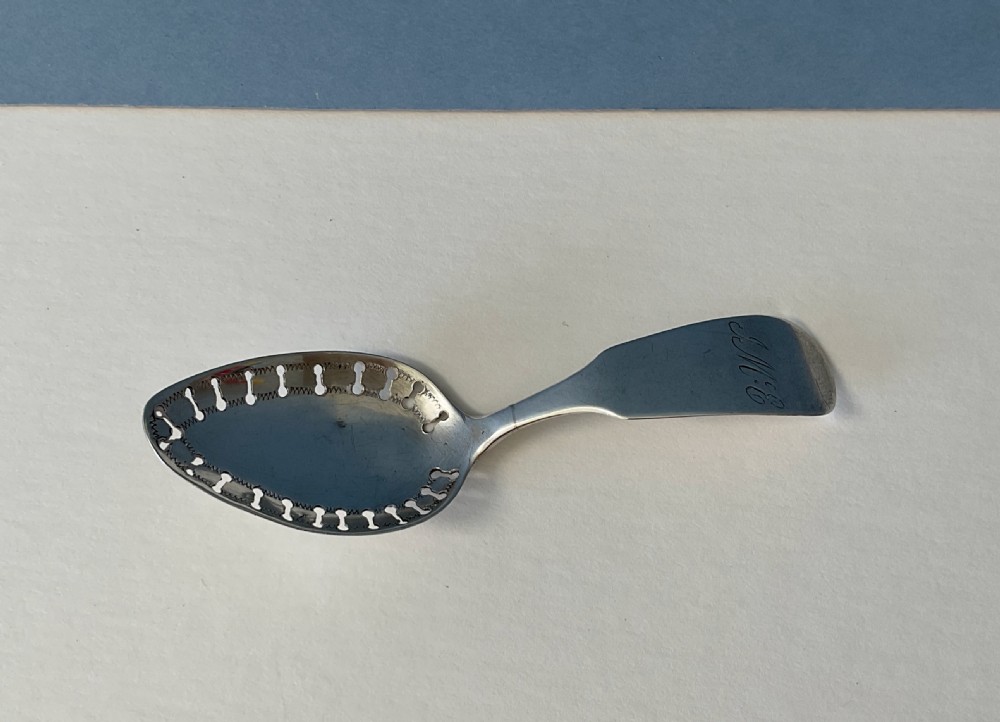 A sterling silver caddy spoon featuring a curved monogrammed handle and a decorative pierced bowl. View IV