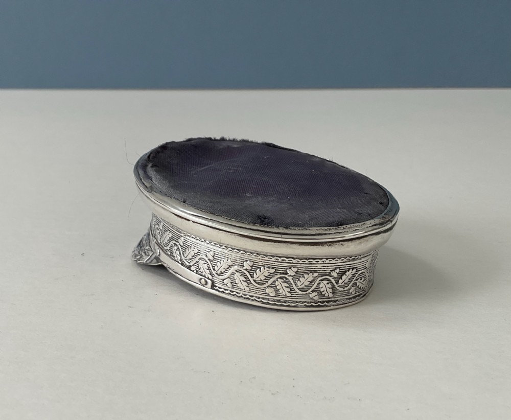 An antique sterling silver novelty pin cushion rendered in the detailed form of a Royal Navy officers cap with a dark fabric top. View V