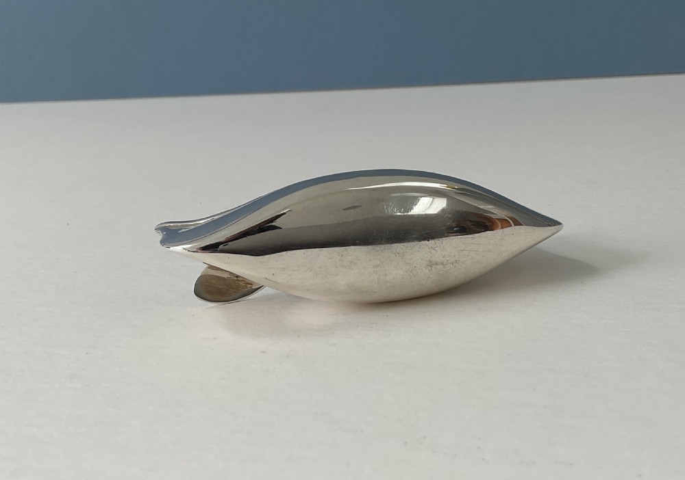 An antique silver canoe-shaped pin cushion featuring a central dark fabric cushion and miniature oar details. View III