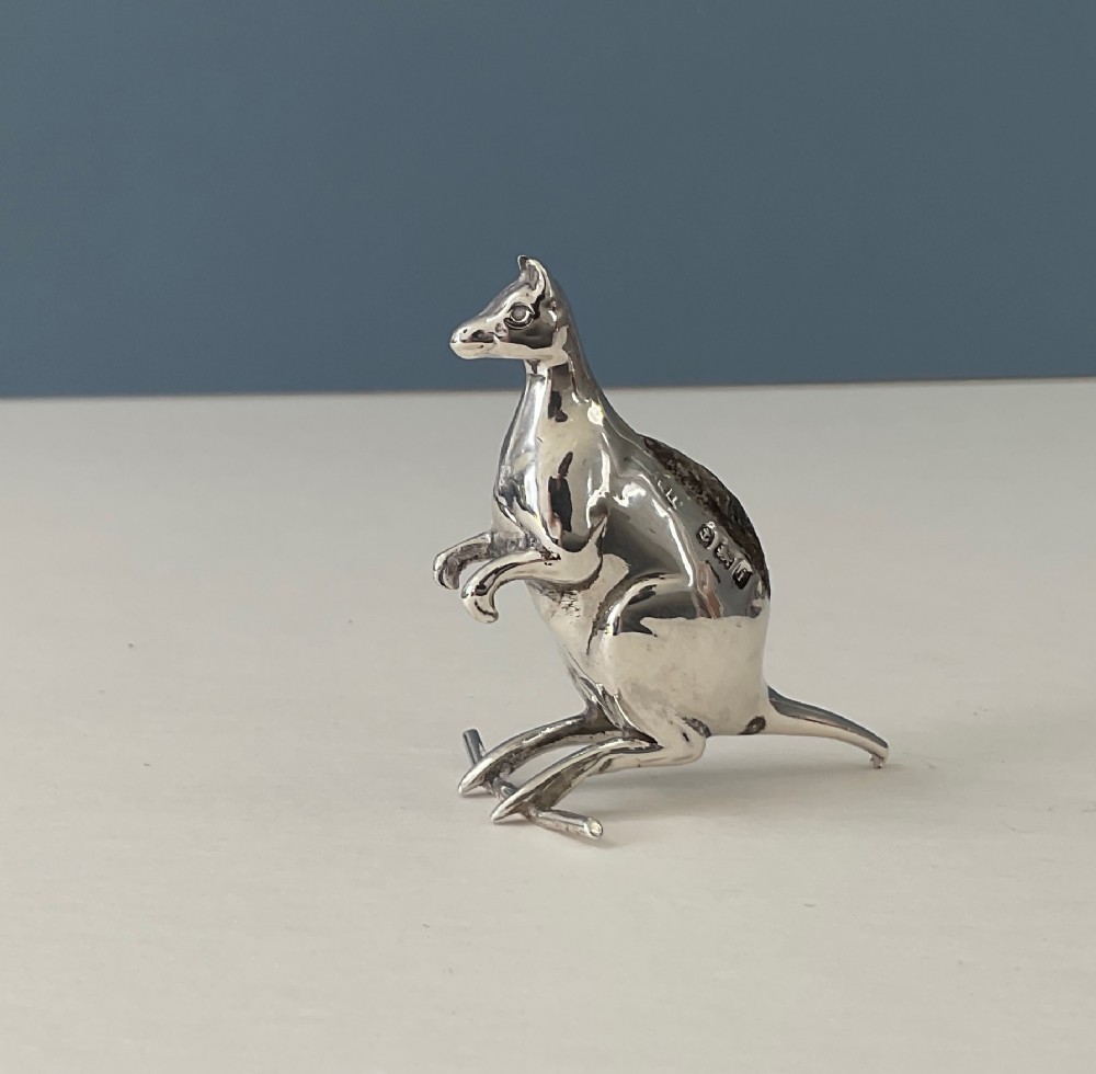 A small hallmarked sterling silver pin cushion cast in the form of a standing kangaroo with a dark fabric insert in its back.