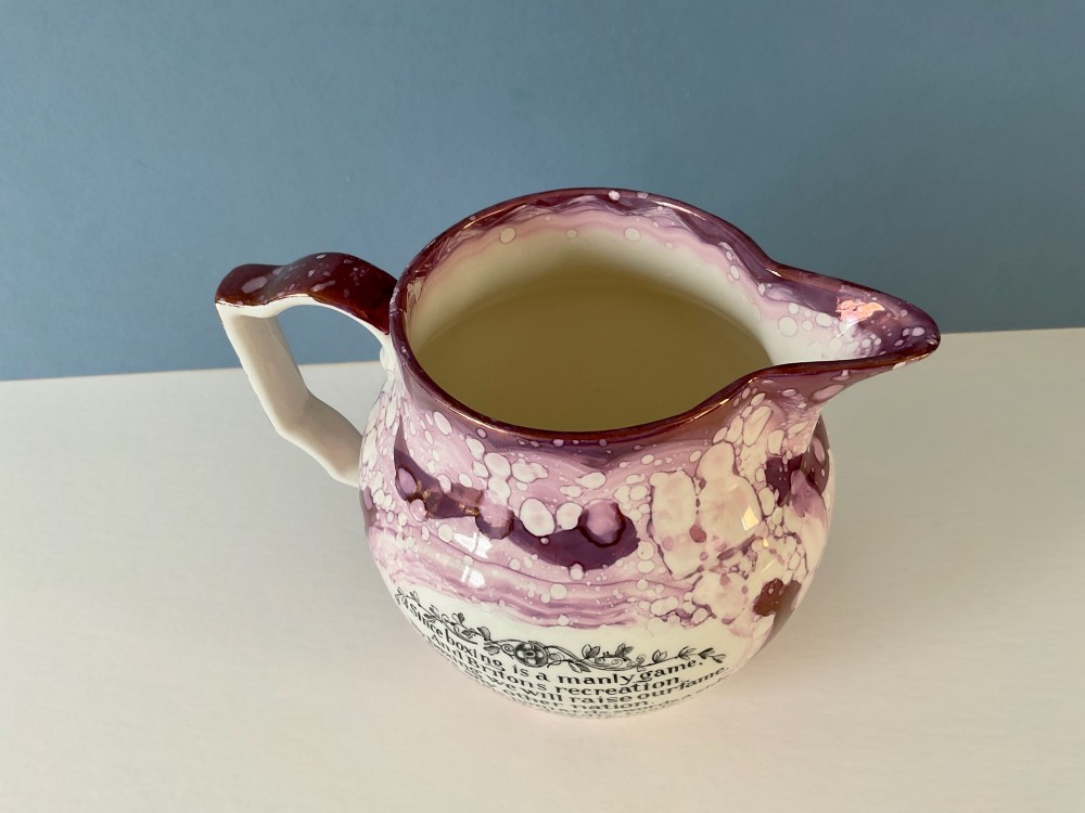 A 19th-century pink splash Sunderland lustre jug decorated with a transfer print depicting two bare-knuckle boxers in a match stance. View VII