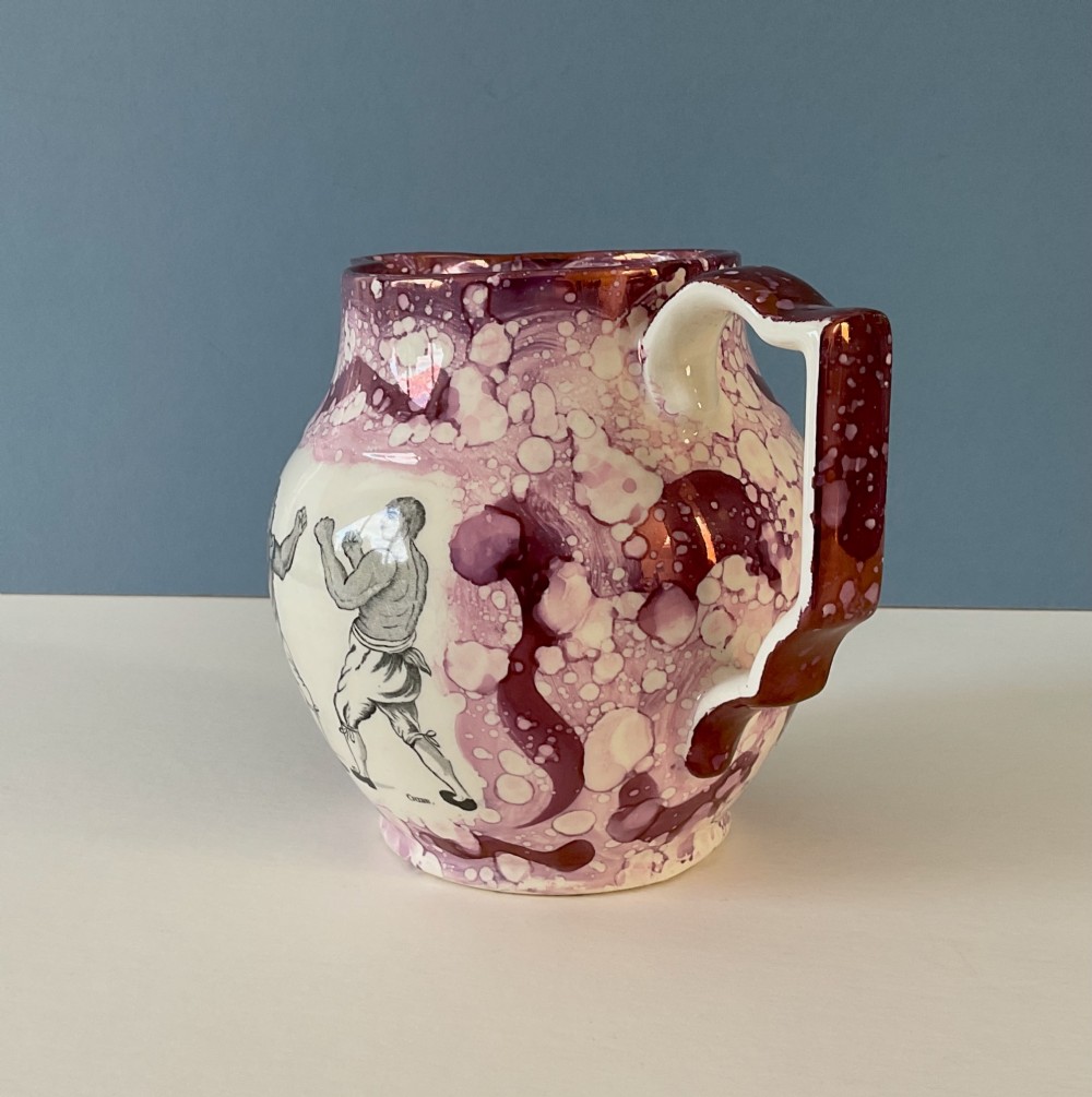A 19th-century pink splash Sunderland lustre jug decorated with a transfer print depicting two bare-knuckle boxers in a match stance. View VIII