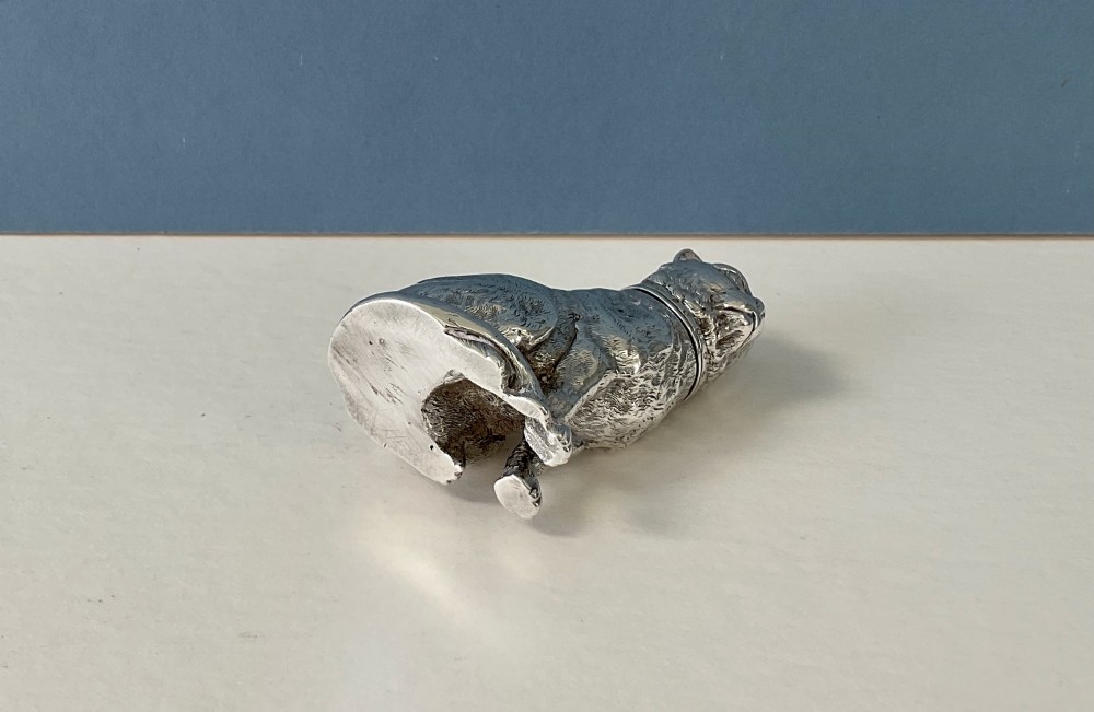 A small silver pepper caster crafted in the form of a seated cat with detailed chased fur and a collar. View IV