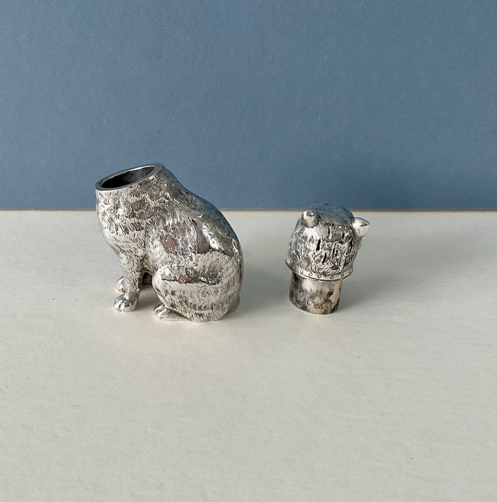 A small silver pepper caster crafted in the form of a seated cat with detailed chased fur and a collar. View VI