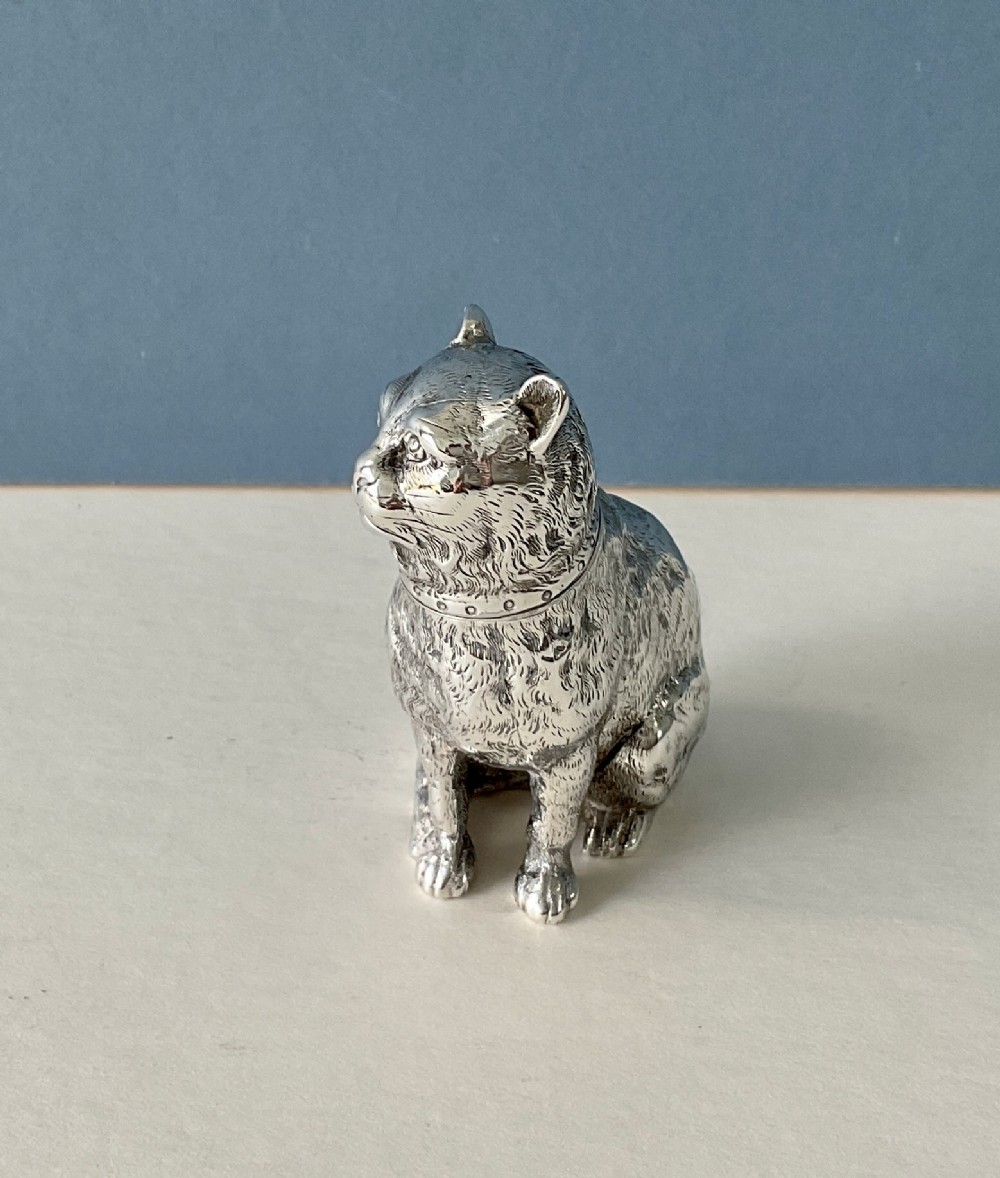 A small silver pepper caster crafted in the form of a seated cat with detailed chased fur and a collar. View VII