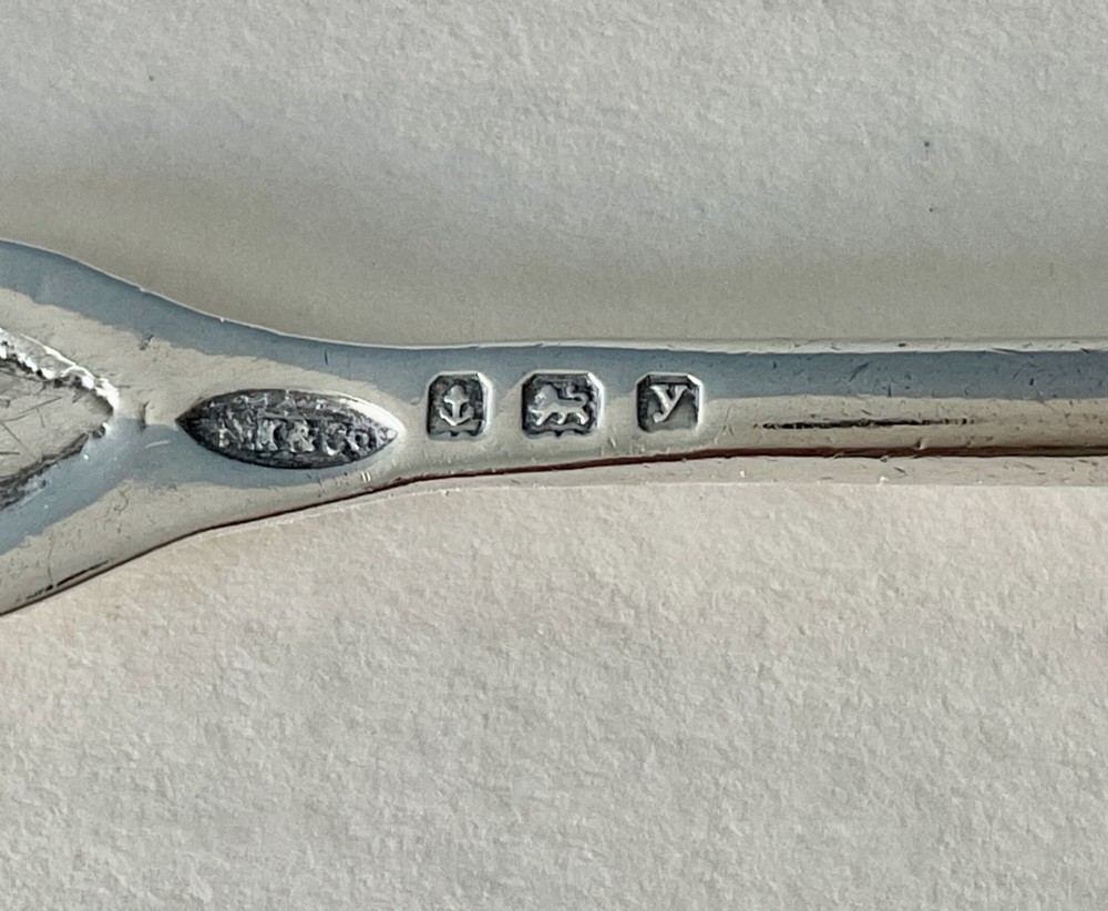 An Arts and Crafts sterling silver caddy spoon featuring a hand-hammered bowl and an intertwined stem handle. View III