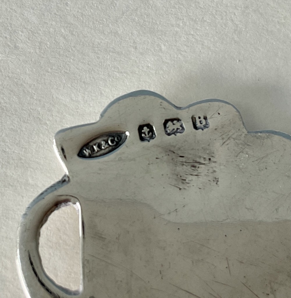 A hand-hammered silver caddy spoon featuring a stylized profile head handle and a teardrop-shaped planished bowl. View III