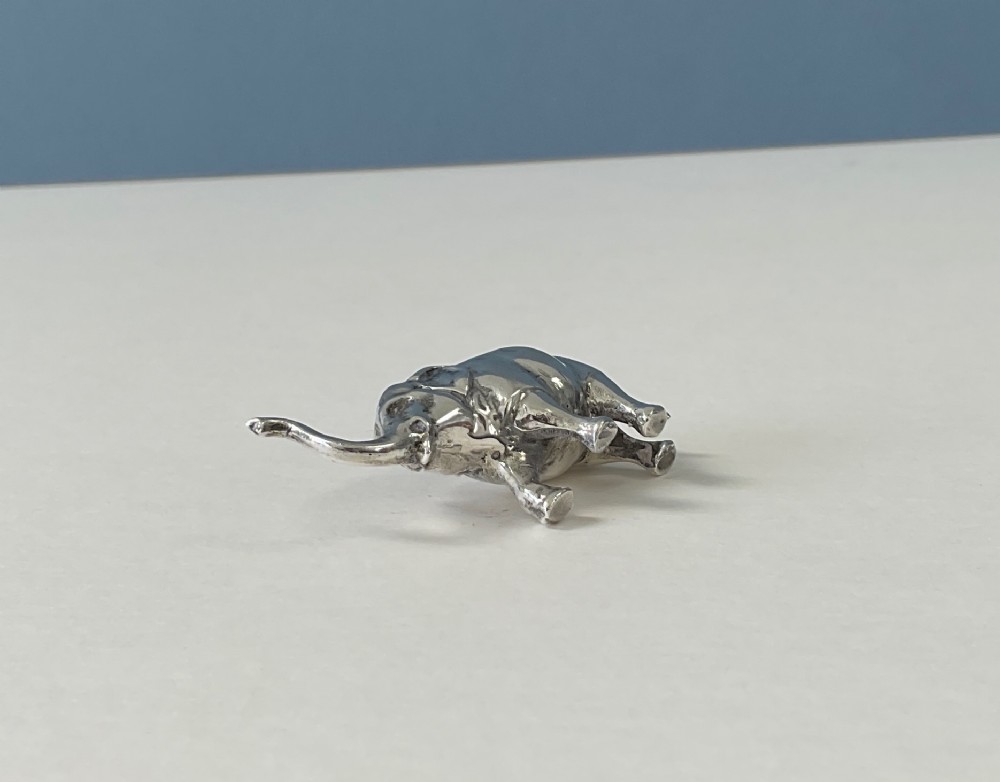 A miniature silver novelty pin cushion cast in the shape of an elephant with a dark fabric insert set into its back. View III