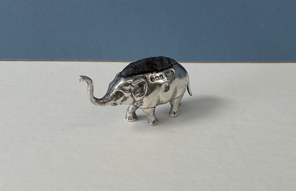 A miniature silver novelty pin cushion cast in the shape of an elephant with a dark fabric insert set into its back. View VIII