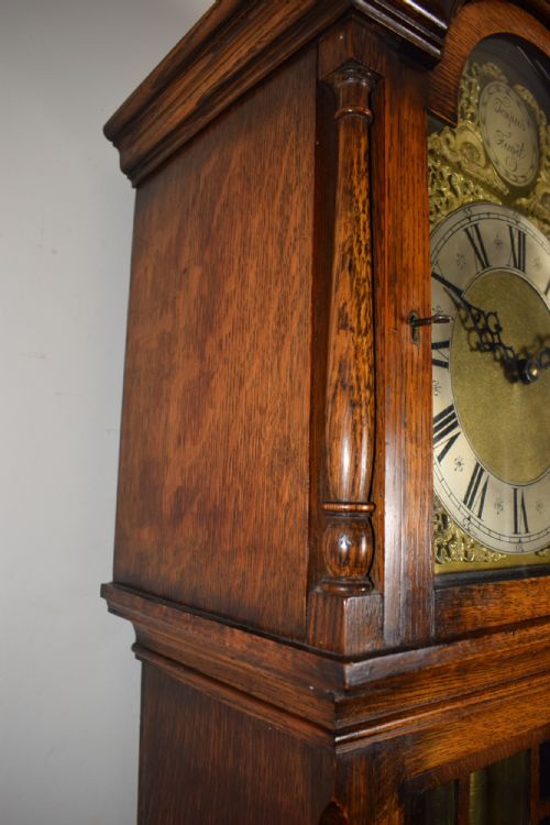 fig 1. Whittington Musical Chiming English Warm Honey Coloured Oak Grandmother or Grandfather Longcase Clock with Glazed Trunk Door Raised on Bracket Feet - Circa 1920