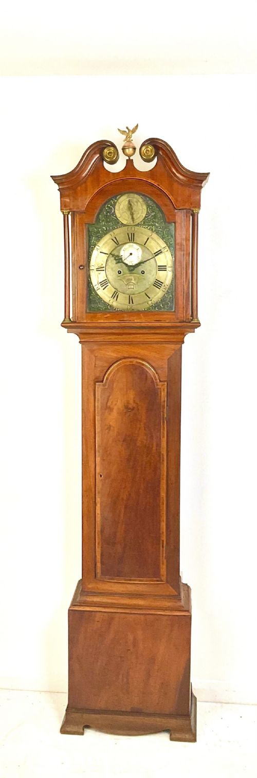 fig 1. A Georgian mahogany longcase clock hood featuring a swan-neck pediment, brass eagle finial, reeded columns, and an engraved brass dial.