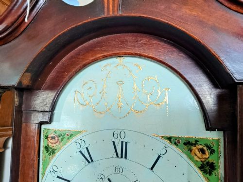 fig 1. A Georgian oak and mahogany longcase clock featuring a swan-neck pediment, brass patera ornaments, fluted columns, and a painted arch dial.