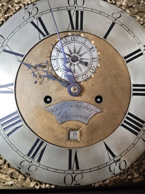 fig 2. An antique Georgian longcase clock in dark mahogany featuring an arched hood and a brass dial with a strike-silent selector.