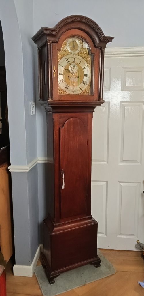 An antique Georgian longcase clock in dark mahogany featuring an arched hood and a brass dial with a strike-silent selector. View XV