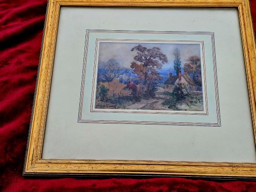 fig 1. An early 20th-century impressionist watercolour painting depicting a rural country lane with trees and a cottage, framed with a layered mount.