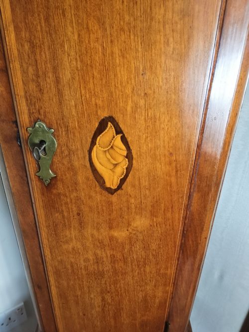 fig 2. A 19th-century mahogany grandfather clock featuring a swan-neck pediment, brass arch dial, and decorative inlaid paterae on the trunk door.