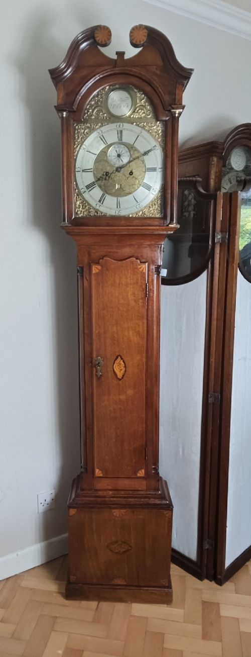 A 19th-century mahogany grandfather clock featuring a swan-neck pediment, brass arch dial, and decorative inlaid paterae on the trunk door. View XIII