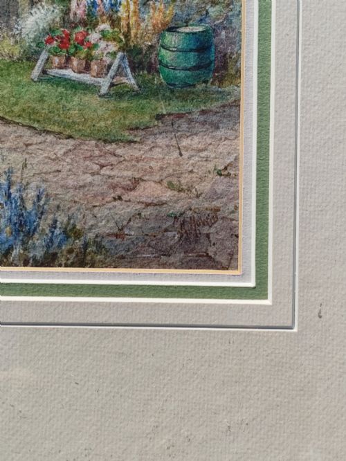 fig 3. A framed vertical watercolour painting depicting a traditional thatched cottage with a garden filled with colourful flowers under a blue sky.