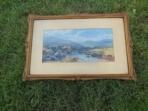 fig 1. A framed Victorian watercolour painting by Tom Rowden depicting cattle standing near a stream in a vast moorland landscape.