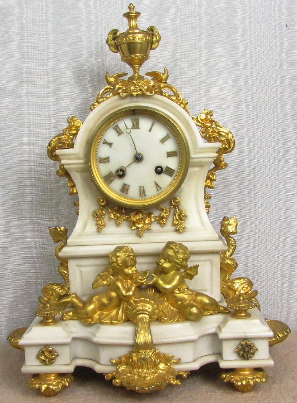 GILT ORMOLU AND WHITE MARBLE LE ROY & FILS PARIS 8 DAY STRIKING CLOCK WITH CHERUBS AND DOLPHINS