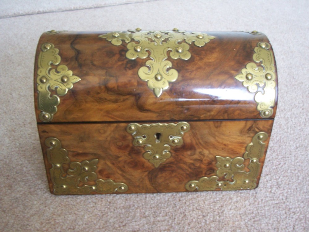 A Victorian burr walnut stationery box featuring a domed lid decorated with pierced brass mounts and corner straps.