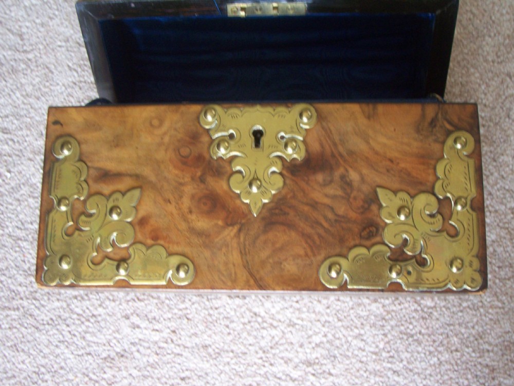 A Victorian burr walnut stationery box featuring a domed lid decorated with pierced brass mounts and corner straps. View VI
