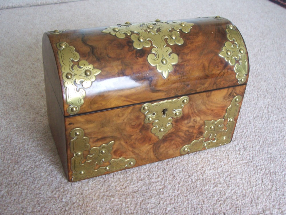 A Victorian burr walnut stationery box featuring a domed lid decorated with pierced brass mounts and corner straps. View X